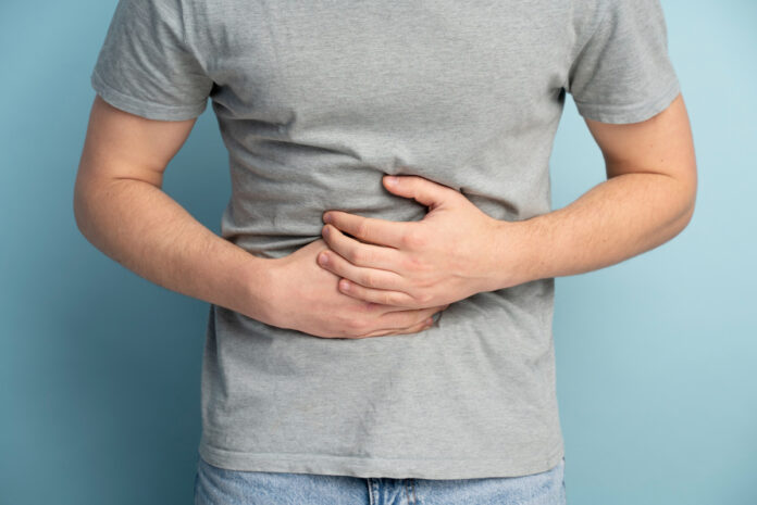 doenças inflamatórias intestinais, homem com mãos na barriga